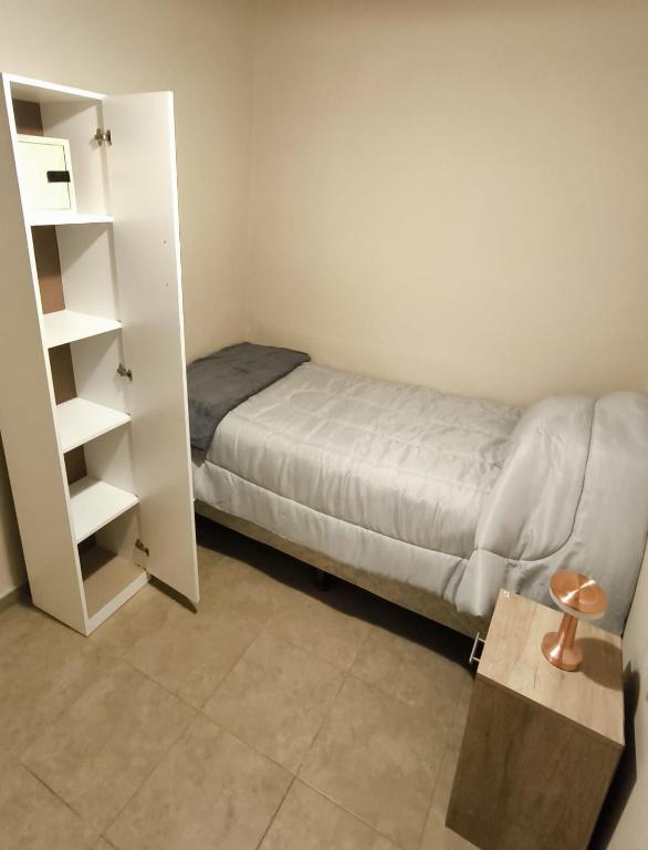 a small bedroom with a bed and a book shelf at Parvis Magna HOSTAL in Barraquero