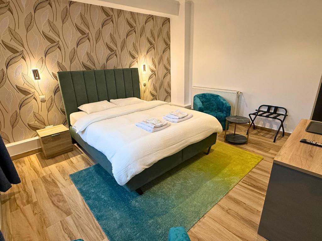 Un dormitorio con una cama con cabecero verde. en Byzanthin rooms, en Bucarest