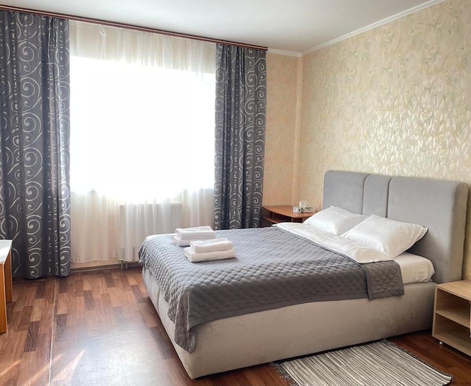 ein Schlafzimmer mit einem Bett und einem großen Fenster in der Unterkunft Затишна однокімнатна квартира Глеваха in Glevakha