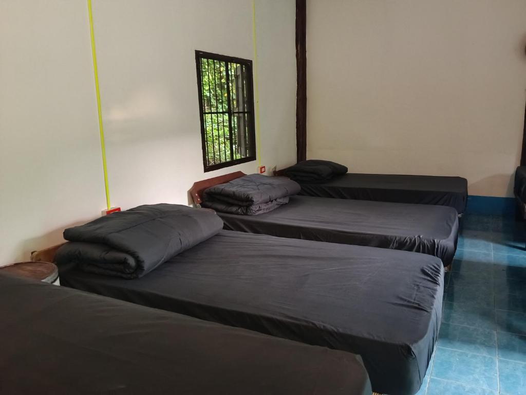 three beds in a room with a window at Easy sleep in Ban Mo Nae
