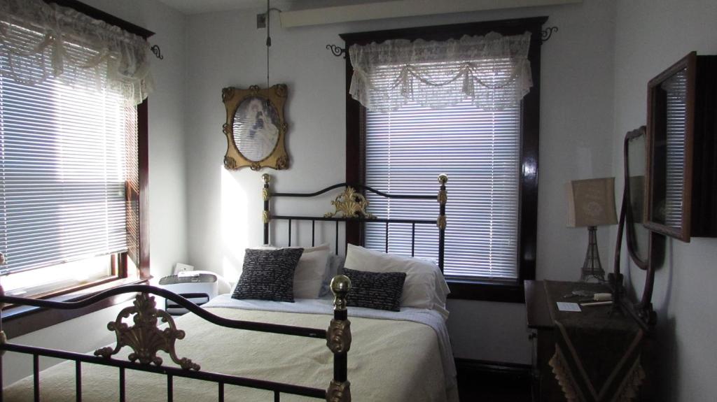 Un dormitorio con una cama y un reloj en la pared. en The Historic Argo Hotel, en Crofton