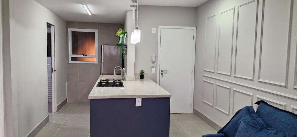 Il comprend une cuisine équipée d'un évier et d'une cuisinière. dans l'établissement Apartamento Novo em São Lourenço, à Bertioga