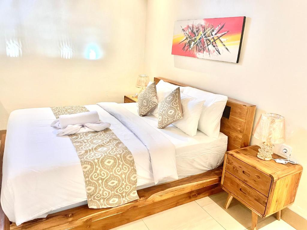 a bedroom with a bed with white sheets and pillows at Puspa Guest House Lembongan in Nusa Lembongan