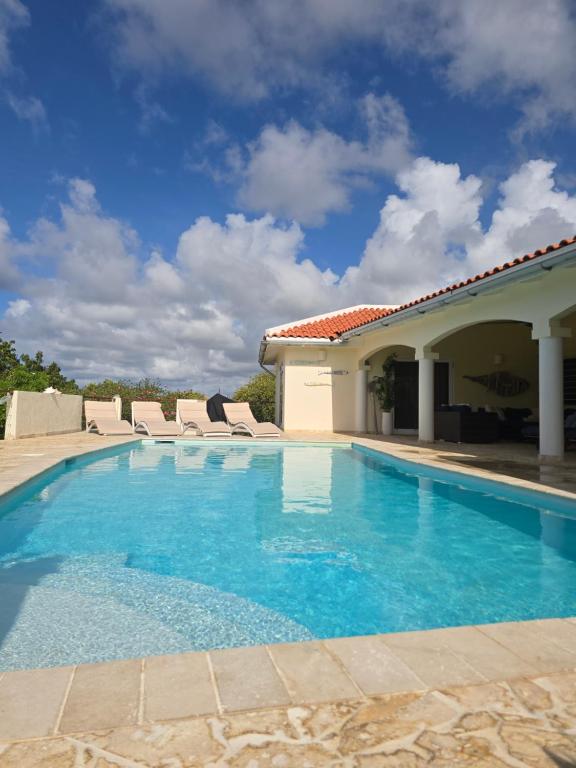ein Swimmingpool mit Stühlen und ein Haus in der Unterkunft Private Family Paradise Villa Ocean View With Private Pool in Kralendijk