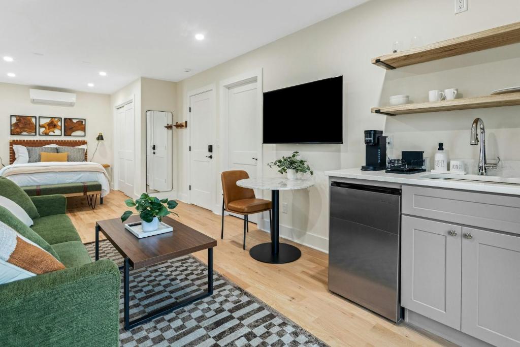 a kitchen and living room with a couch and a bed at Glenbrook Suites in Stamford