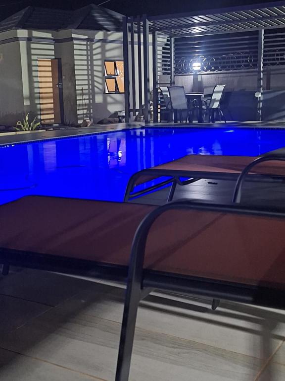 a swimming pool in a room with blue lighting at EuniBot Guest House in Francistown