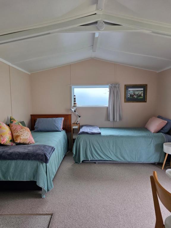 a bedroom with two beds and a window at Captains Quarters in Ohope Beach