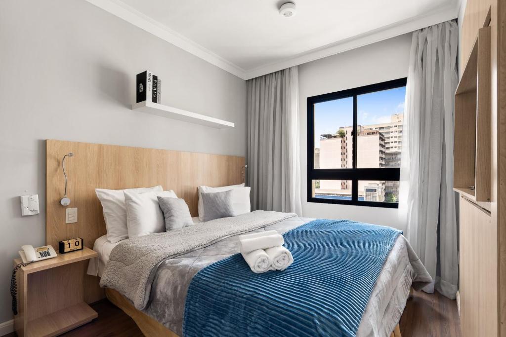 a bedroom with a bed with two towels on it at Suítes Inside The Universe Paulista in Sao Paulo