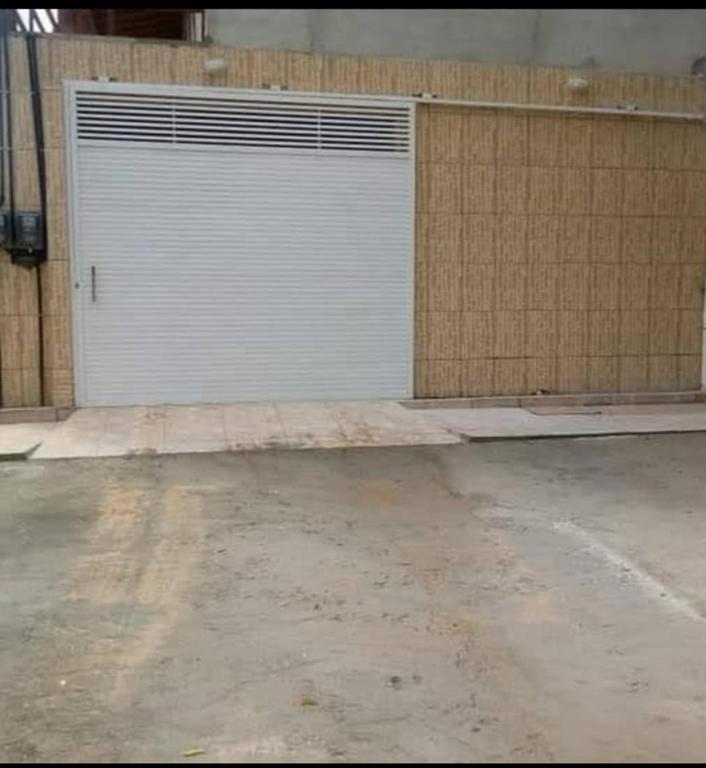 a white garage door in front of a building at Casa das dunas in Prea