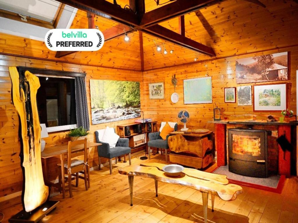 a living room with a fireplace in a log cabin at Vintage chalet in a very beautiful landscape in Aywaille