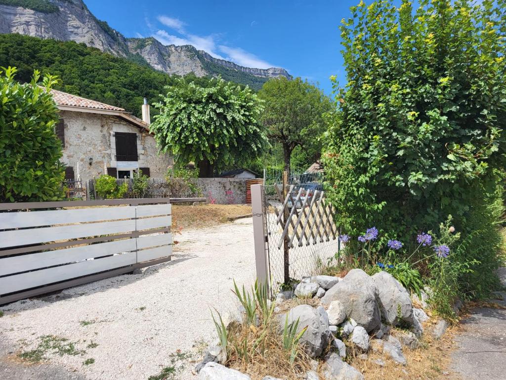 una recinzione di fronte a una casa con una montagna di Naëlo Chartreuse a Biviers