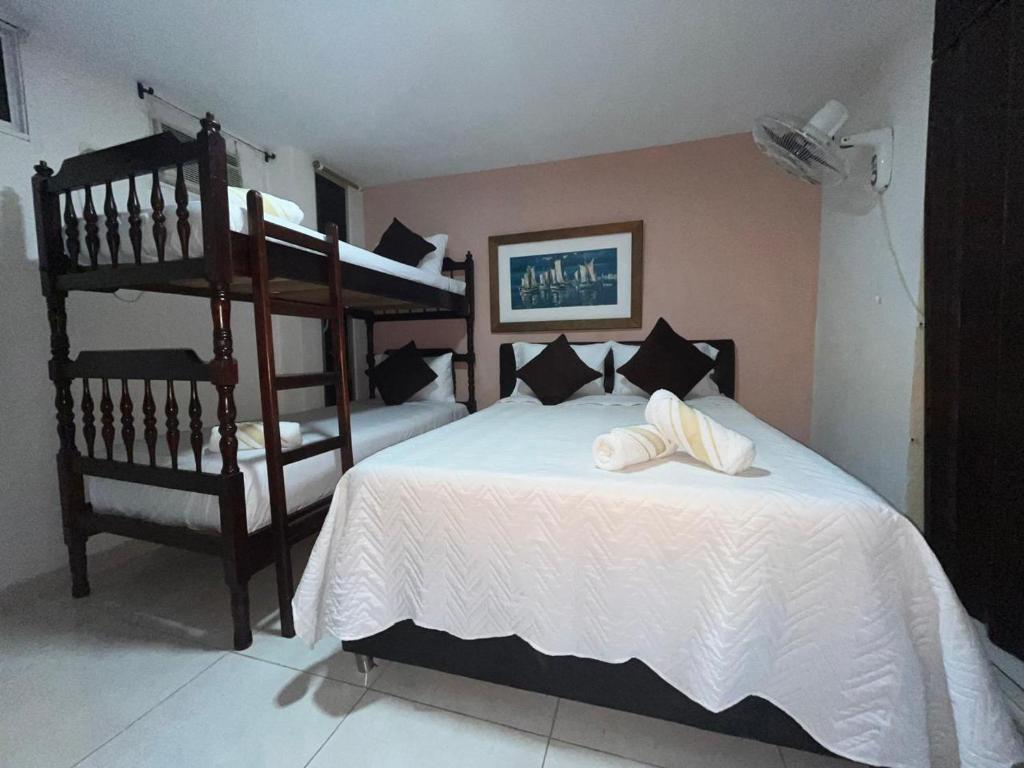 Un dormitorio con dos literas y una cama blanca. en Hermosa Vista al Mar en Rodadero, en Gaira