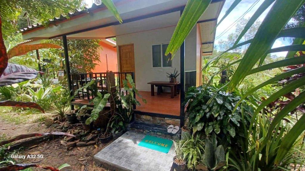 a small house with a porch with plants at Chalee Guest House in Ban Khlong Mat