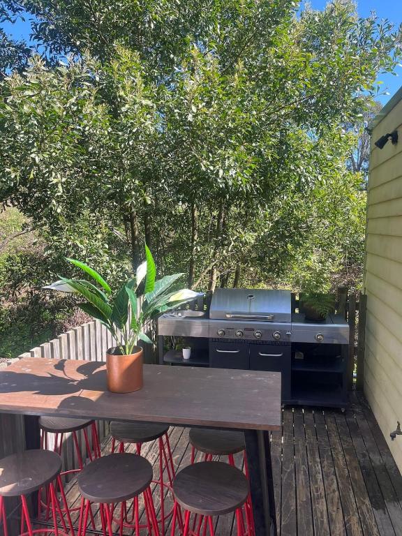 a picnic table with a grill and some stools at Private Accommodation at the Megaranch in Nyora