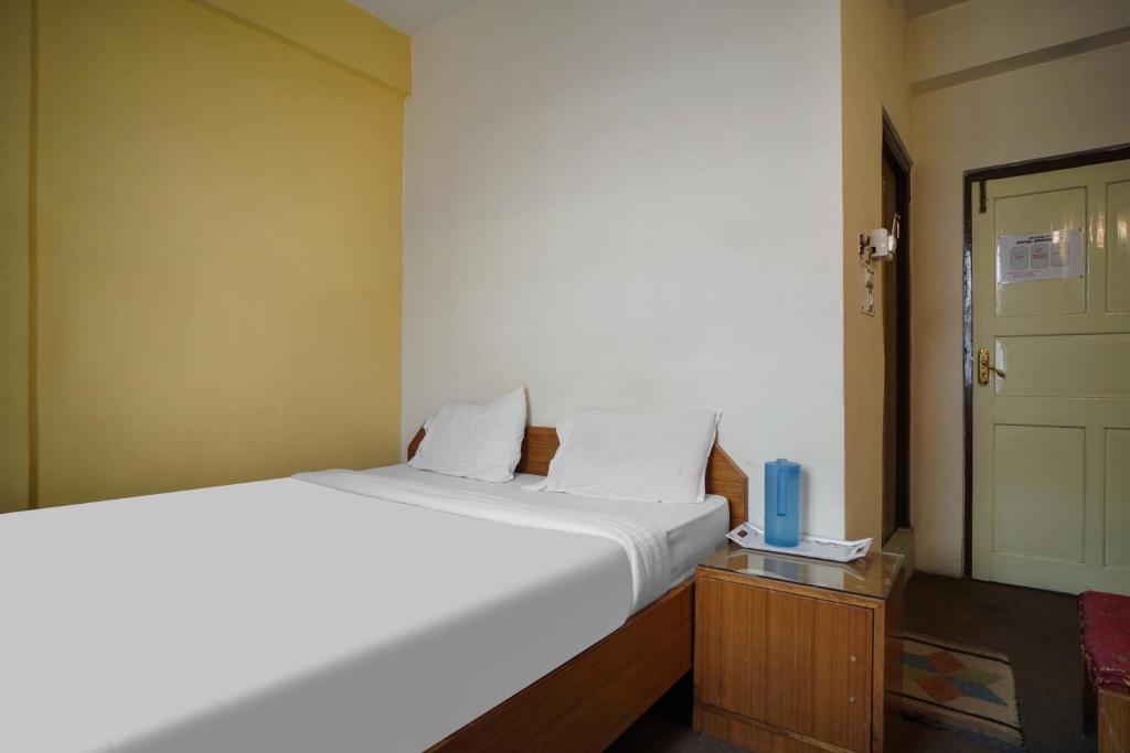 甘托克Collection O SHANTI PRIYA的卧室配有一张白色的大床和一扇门