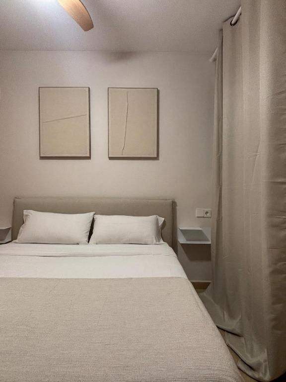 a bed in a room with two pictures on the wall at Cosy Flat Valencia in Masanasa