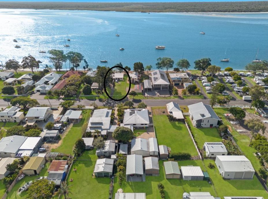 an aerial view of a suburb with houses and the ocean at Beachcomber in Burrum Heads