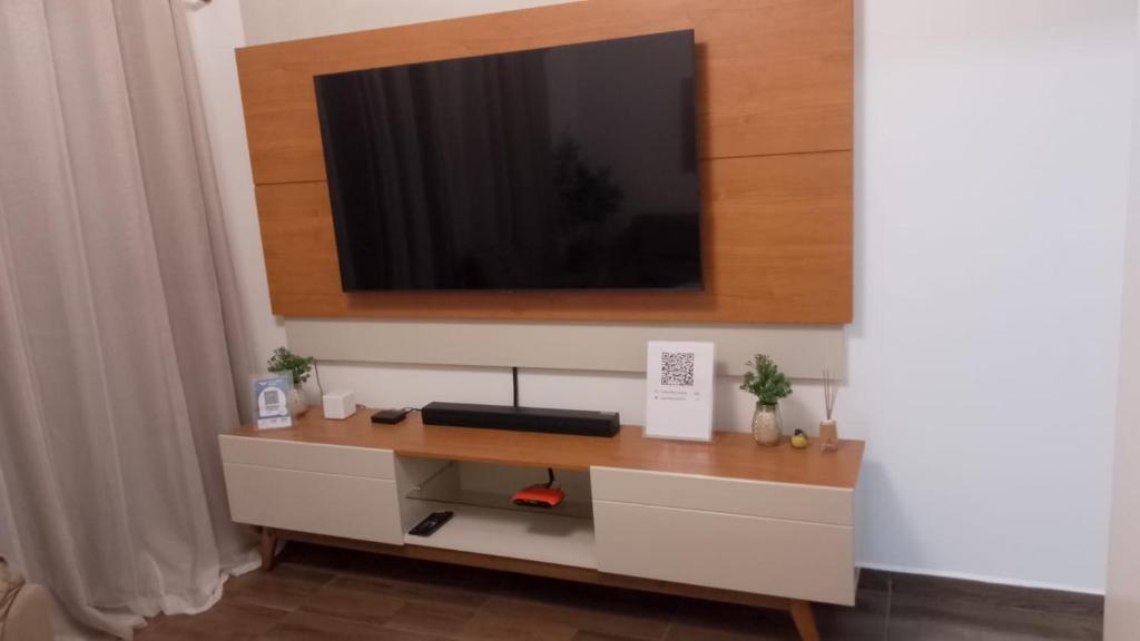 uma sala de estar com uma TV na parede em Apartamento Inteiro - Casa Nostra Guest House 1 - Nomad Ready em Belém