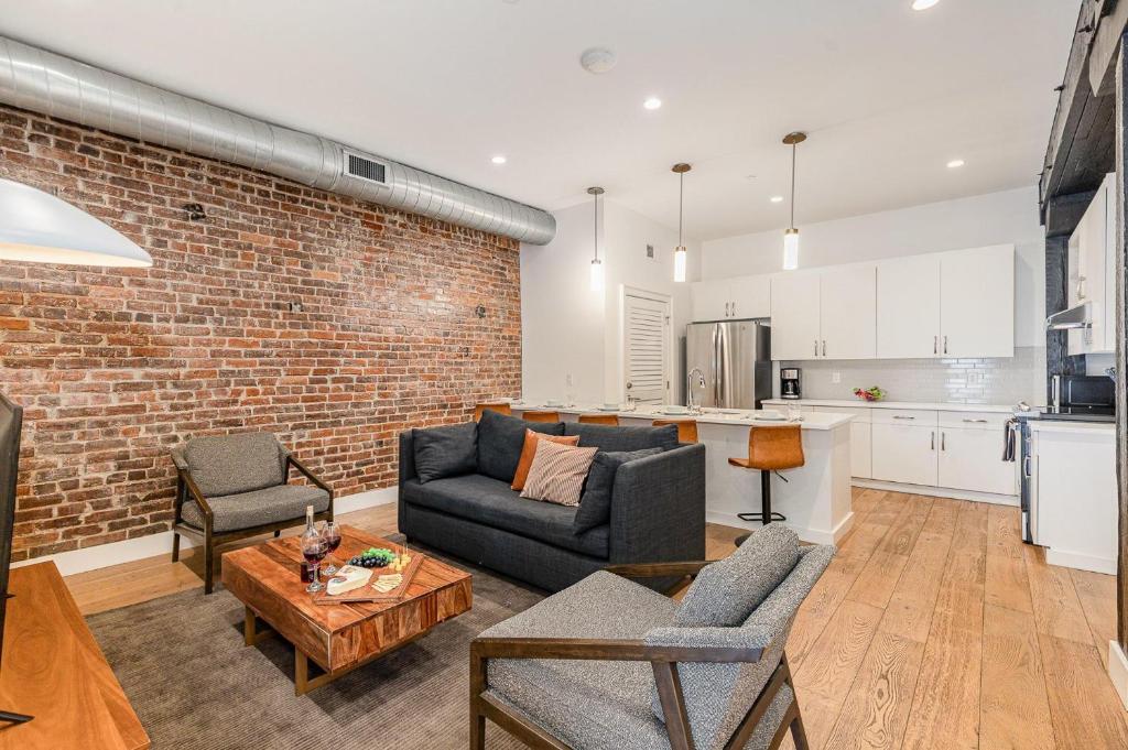 ein Wohnzimmer mit einer Couch und einer Ziegelwand in der Unterkunft The Saddlery - Encore - 1 Block to Broadway in Nashville