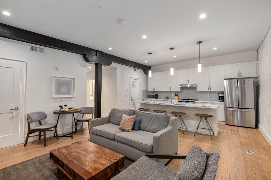 Una sala de estar con un sofá y una cocina. en The Saddlery - Spotlight - 2 Min Walk to Broadway, en Nashville