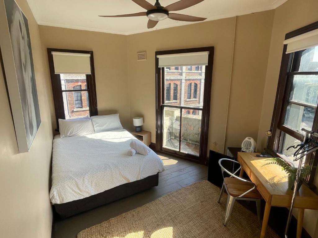 a bedroom with a bed and a ceiling fan at Glengarry Castle Hotel in Sydney