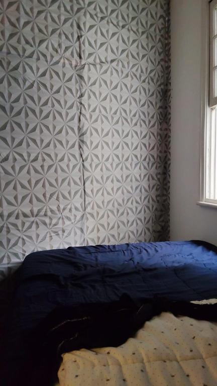 a bedroom with a blue bed and a wall at Quarto compartilhado para Homens in Sao Paulo