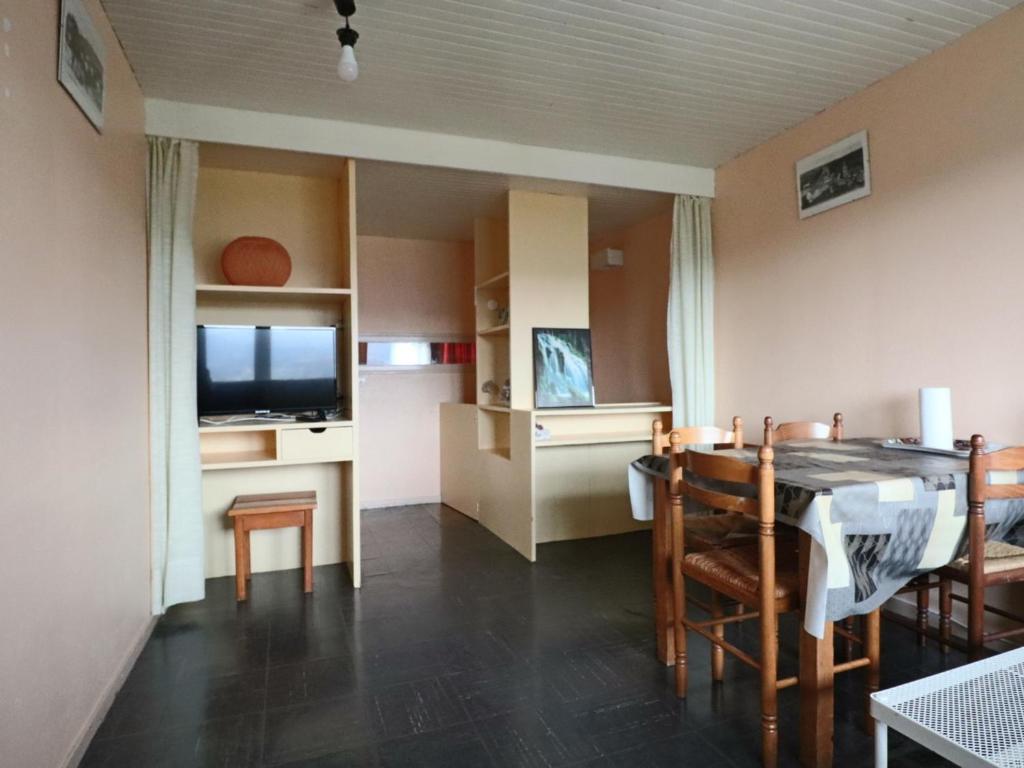 a living room with a dining room table and a television at Charmant Duplex 4 Pers. avec Parking Privé à Murat-le-Quaire - FR-1-858-9 in Murat-le-Quaire