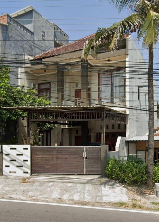 a house with a wooden gate and a palm tree at Villa Hayoo ayem in Sukowati