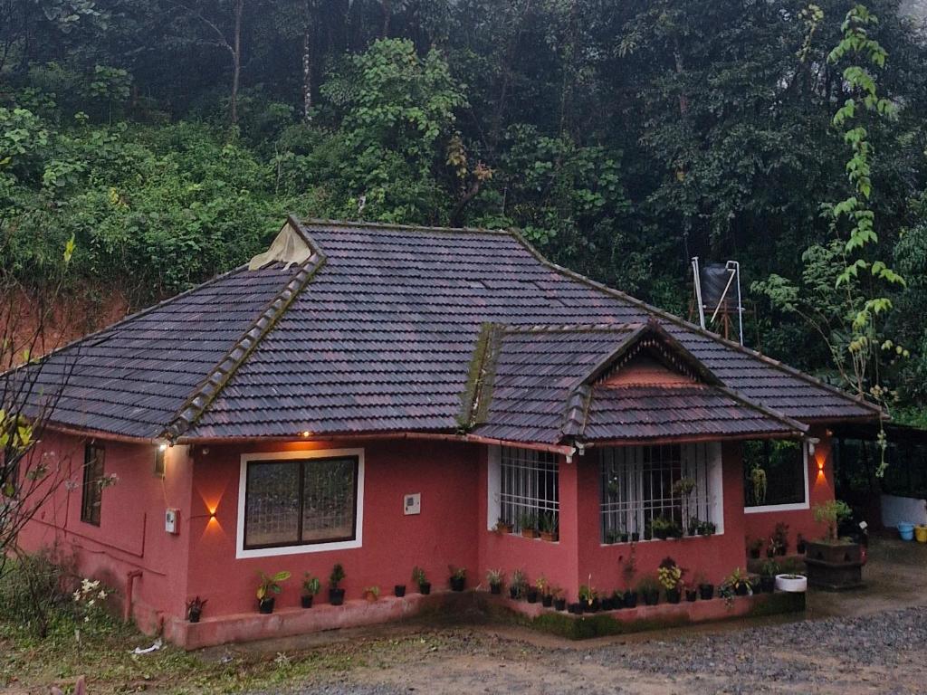 a red house with a black roof at The Aurora Coorg in Madikeri