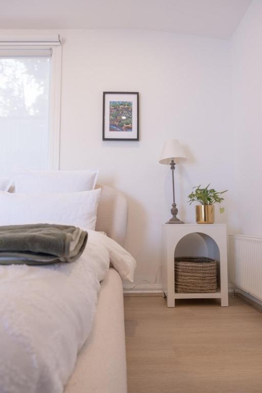 a white bedroom with a bed and a fireplace at Modern room in Williamstown in Williamstown