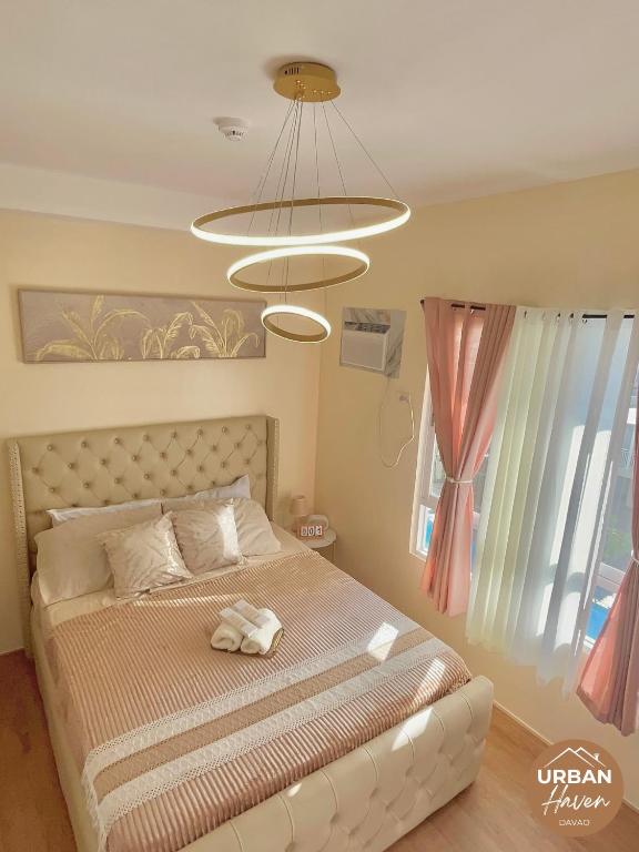 een slaapkamer met een bed en een groot raam bij Urban Haven Davao in Davao City