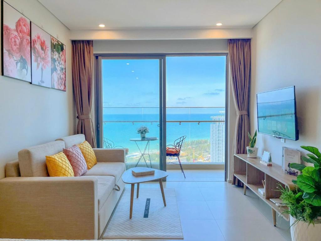 THE SONG CĂN HỘ GẦN BÃI SAU THÁP TAM THẮNG - Po'sHomestay Luxury Bãi Sau في فنغ تاو: غرفة معيشة مع أريكة ونافذة كبيرة