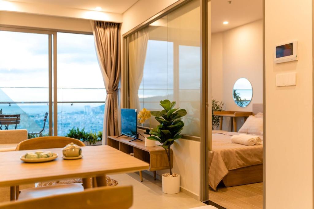 a bedroom with a bed and a table with a laptop at THE SONG CĂN HỘ GẦN BÃI SAU THÁP TAM THẮNG - Po'sHomestay Luxury Bãi Sau in Vung Tau