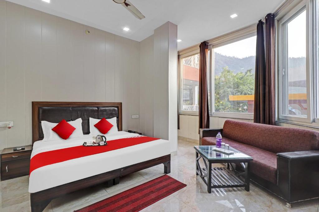 a bedroom with a large bed and a couch at HOTEL O LAXMAN GRAND in Tapovan