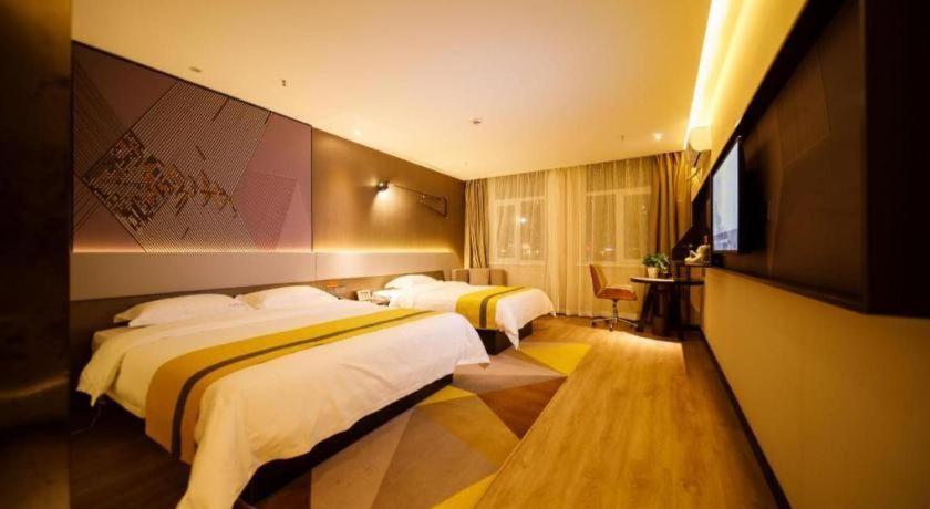 a hotel room with two beds and a television at IU Hotels· Xincheng Haibing University Store in T'ao-hua Tao