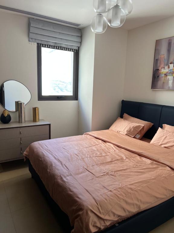 Un dormitorio con una cama y un espejo y una ventana. en Muscat Bay ! - Stay Where Ocean, Mountains and Luxury Come Together !, en Mascate