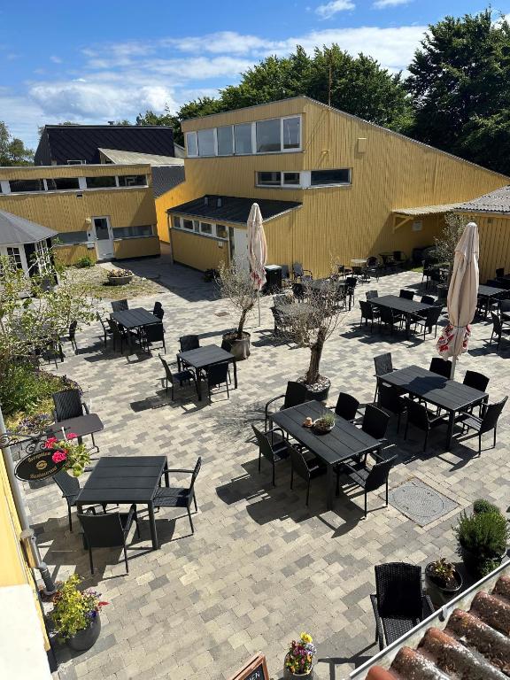 a patio with tables and chairs and a building at Oasen Samsø in Nordby