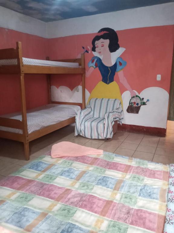 een kamer met twee stapelbedden en een vrouw op de muur geschilderd bij Hostal the Cats in Panajachel