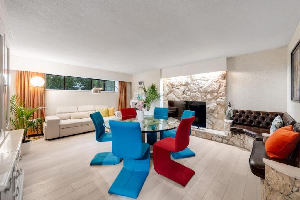 een woonkamer met een glazen tafel en kleurrijke stoelen bij Vacation Home in Van West in Vancouver