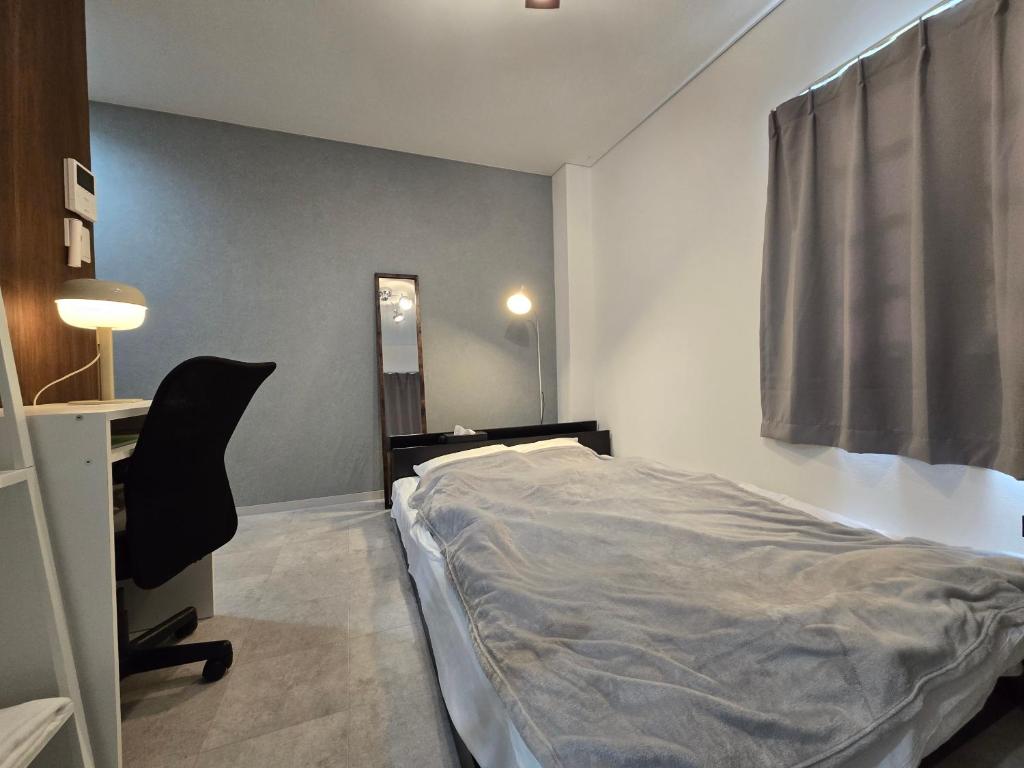 a bedroom with a bed and a desk and a chair at SABBATH uzumaza 103 in Kyoto