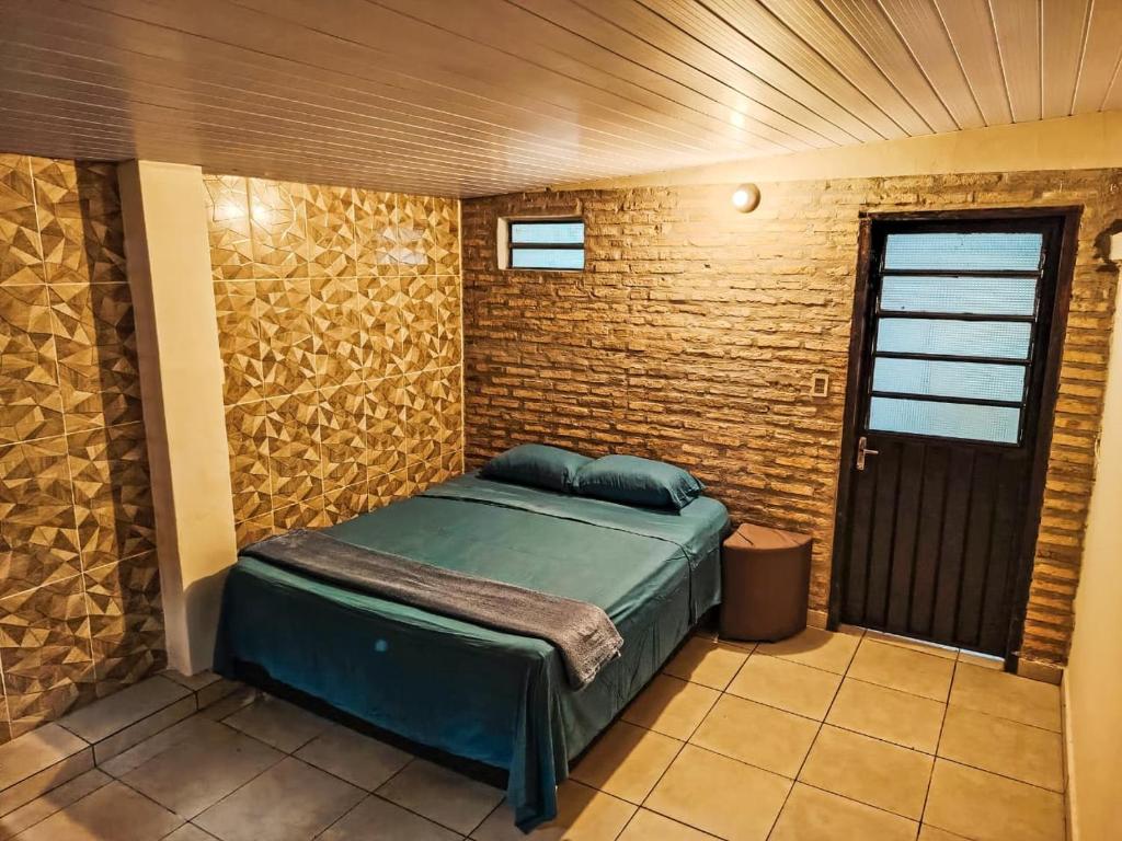 ein Schlafzimmer mit einem Bett in einer Ziegelwand in der Unterkunft Hospedaje SKYHOME II in Nu Guazu