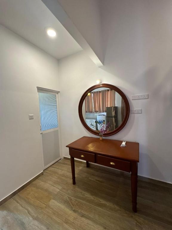 a room with a wooden table and a mirror at Euphoria Villa in Hikkaduwa