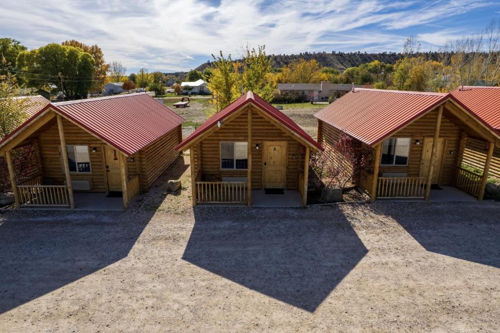 a row of wooden cabins with red roofs at Bryce Canyon Log Cabins in Tropic