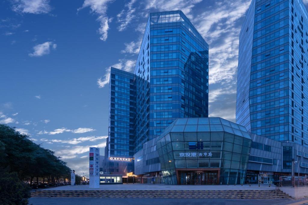 deux grands immeubles de verre dans une ville au crépuscule dans l'établissement Kouring Ruiyue Hotel Guogongzhuang Subway Station Branch, à Pékin
