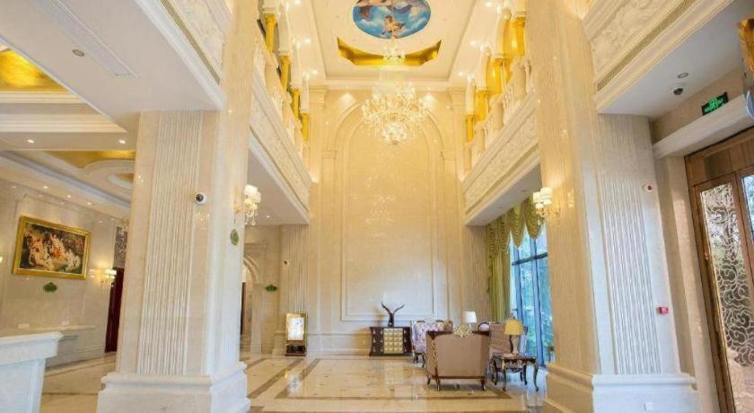 a large lobby with columns and a chandelier at Vienna International Shanghai Nanxiang in Chenjiahang