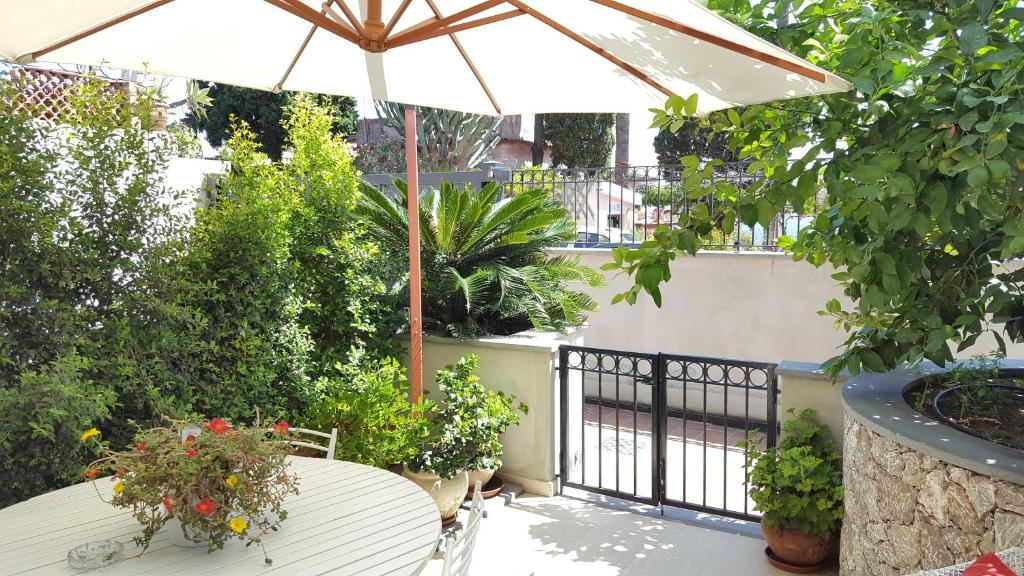 a patio with a table and an umbrella at Appartamento Verde Taormina in Taormina