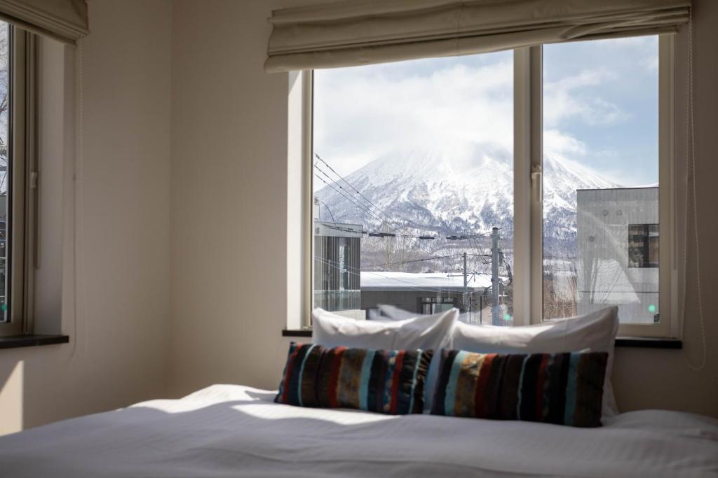 a bedroom with a window with a view of a mountain at Yukisawa House in Kutchan