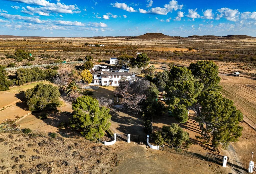 CarnarvonDellville Country House & Cottages的沙漠中树木繁茂的房子的空中景观