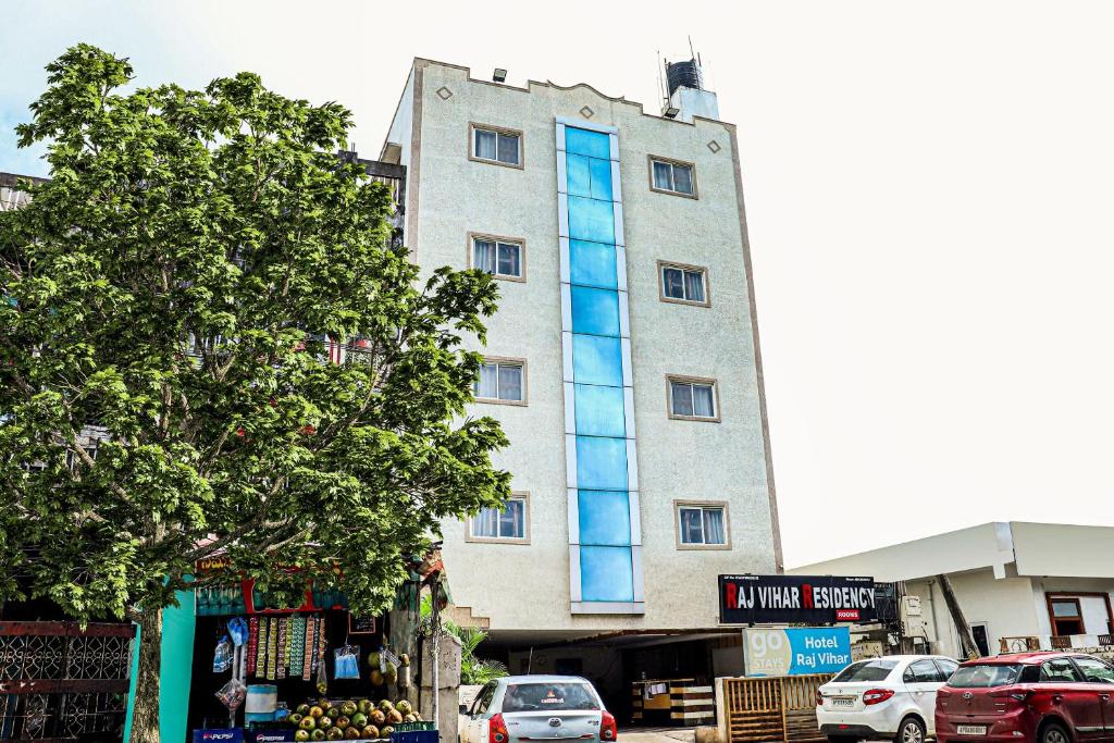 un edificio alto con ventanas azules en una calle en Hotel O Raj Vihar, en Mohammadnagar