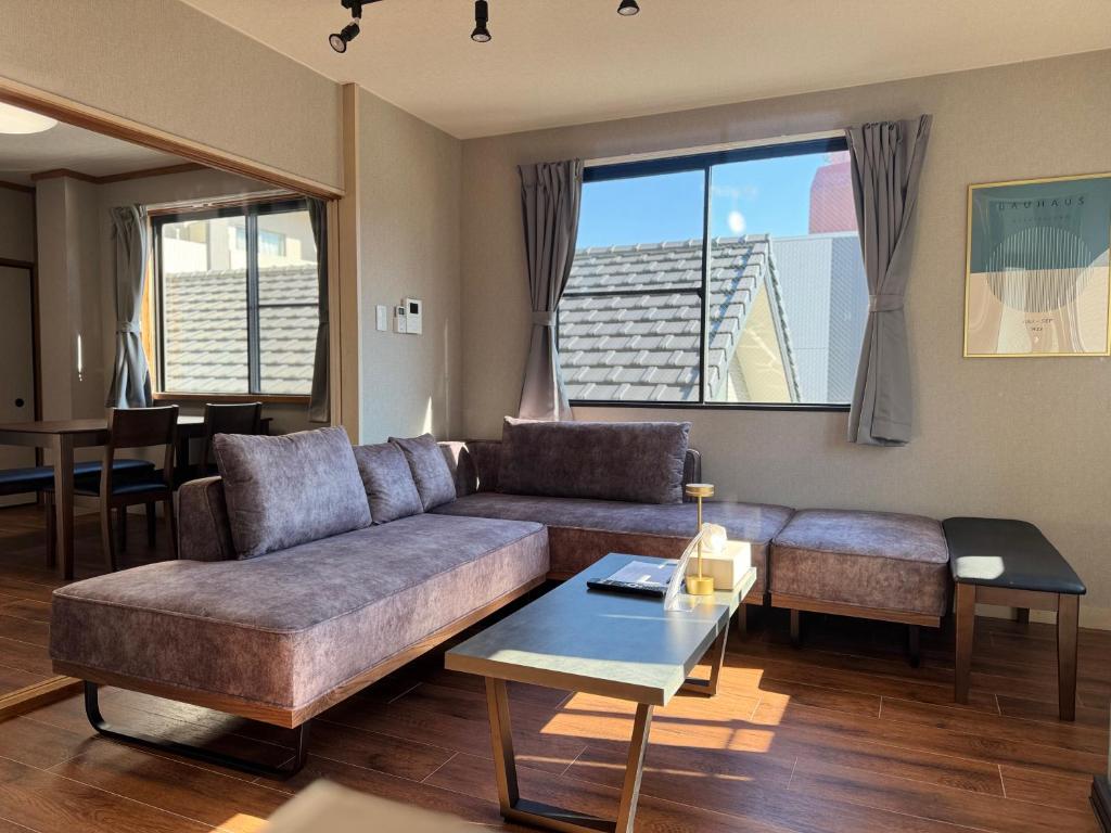 a living room with a couch and a table at UNITED GARDEN hotel 宇都宮駅前3階 in Utsunomiya